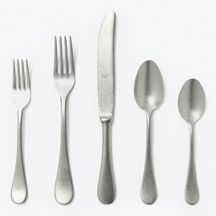 Set of stainless steel cutlery with two forks, knife, spoons.