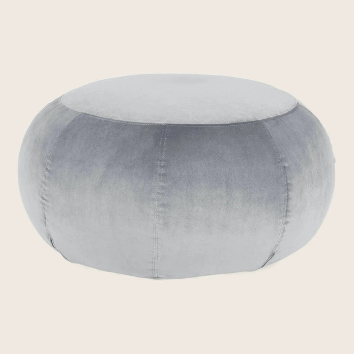 Plush grey velvet pouf with stitched seams on white background.