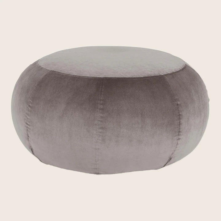 Symmetrical gray velvet pouf with visible vertical stitches on white background.
