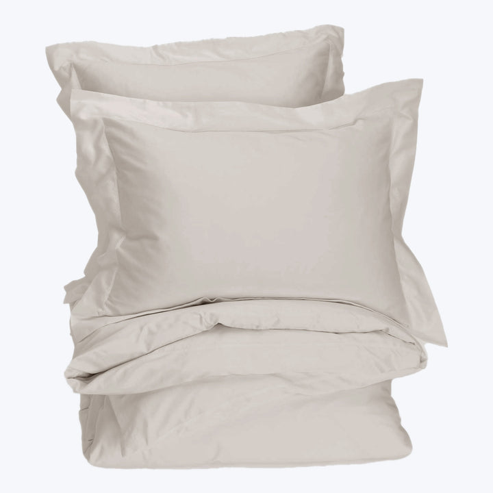 Neutral colored bedding set displayed in a stack, soft fabric