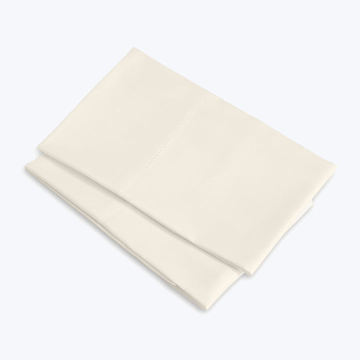 Neatly folded cream cloth on gray background, soft lighting.