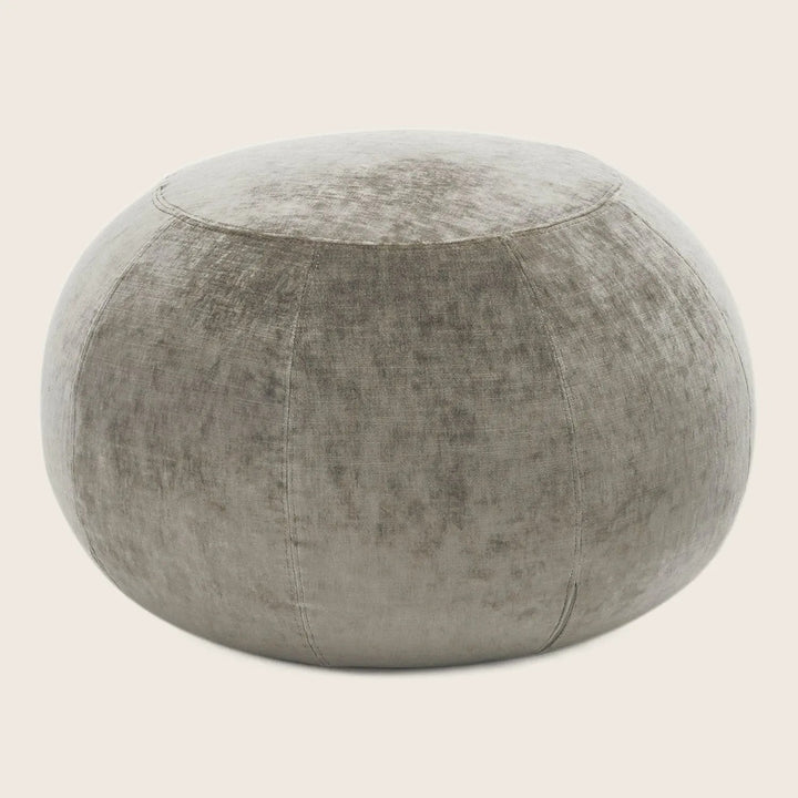 Neutral gray upholstered pouf with distressed texture and visible stitching.