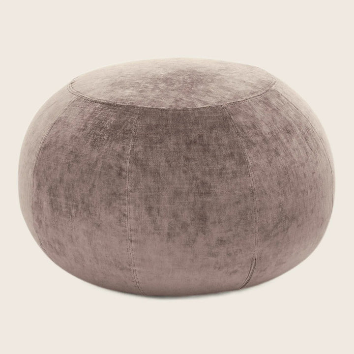 Velvety mauve ottoman adds a touch of elegance to any space