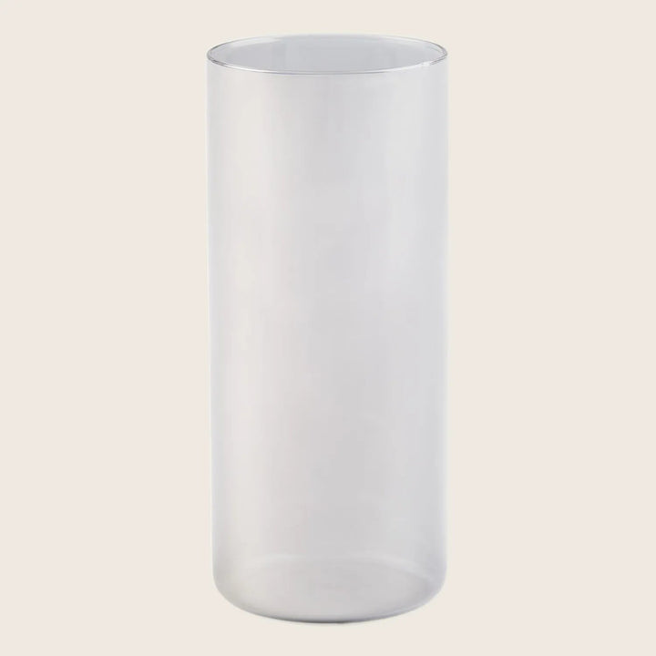 Minimalist clear glass vase on white background with light gradient.