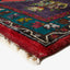 Colorful folded rug with intricate patterns, thick plush pile texture.