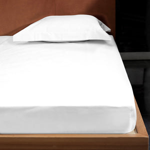 Crisp, white bed sheets neatly stacked in minimalist setting. - hover