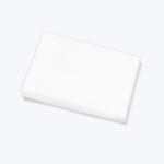 Folded white fabric against white background, creating shadows and depth.