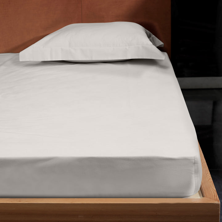 Minimalist, modern bed with white sheets and pillow without case.