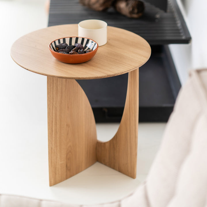 Minimalist side table with ceramic bowl, mug, and decor objects.