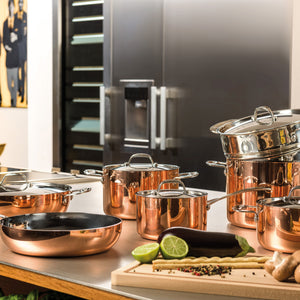 A polished copper pot with silver lid for efficient cooking. - hover