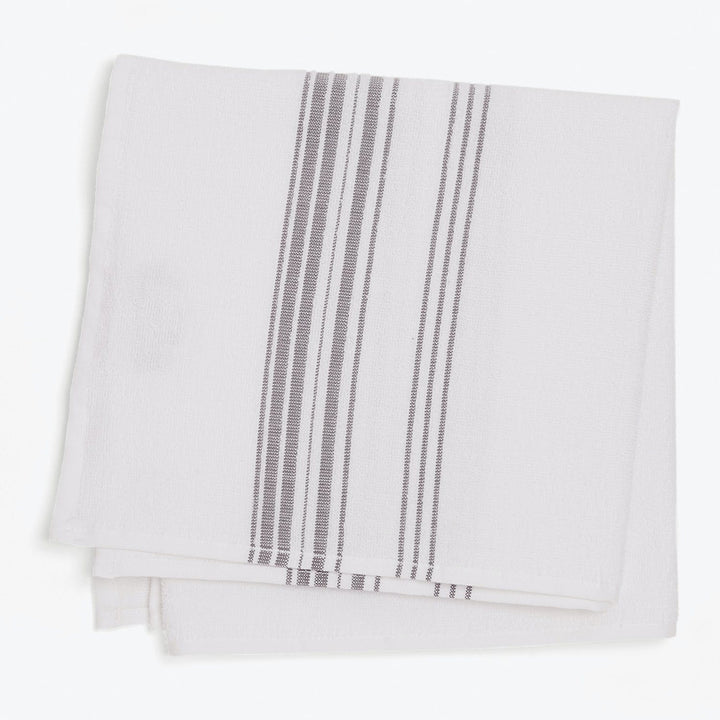 Neatly folded white dishtowel with vertical stripe design in monochrome.