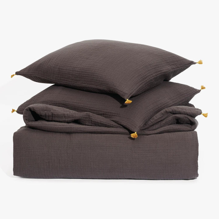 Brown bedding set with textured design and decorative tassels displayed