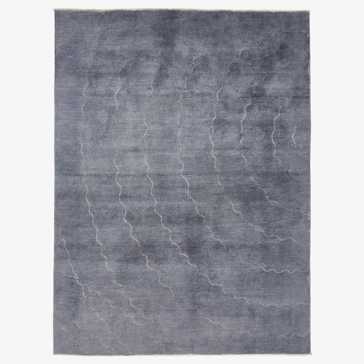 Monochromatic gradient rug with organic wave pattern in shades of gray.