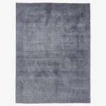 Monochromatic gradient rug with organic wave pattern in shades of gray.