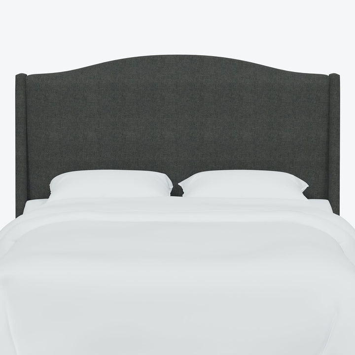 Minimalist gray upholstered headboard with white bedding and pillow.