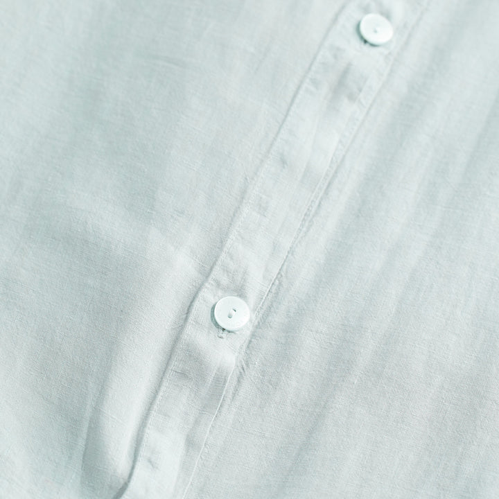 Elegant shirt with light buttons and fine textured fabric weave.