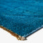 Close-up of blue carpet corner with dense soft pile texture.