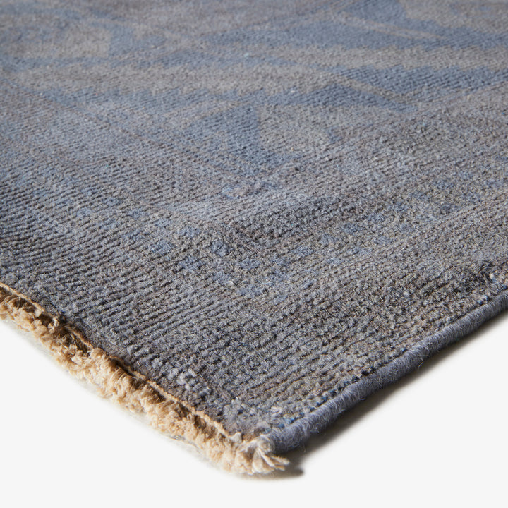 Close-up of plush grey rug with textured geometric design.