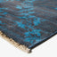 Close-up of modern blue patterned rug with fringe detail.