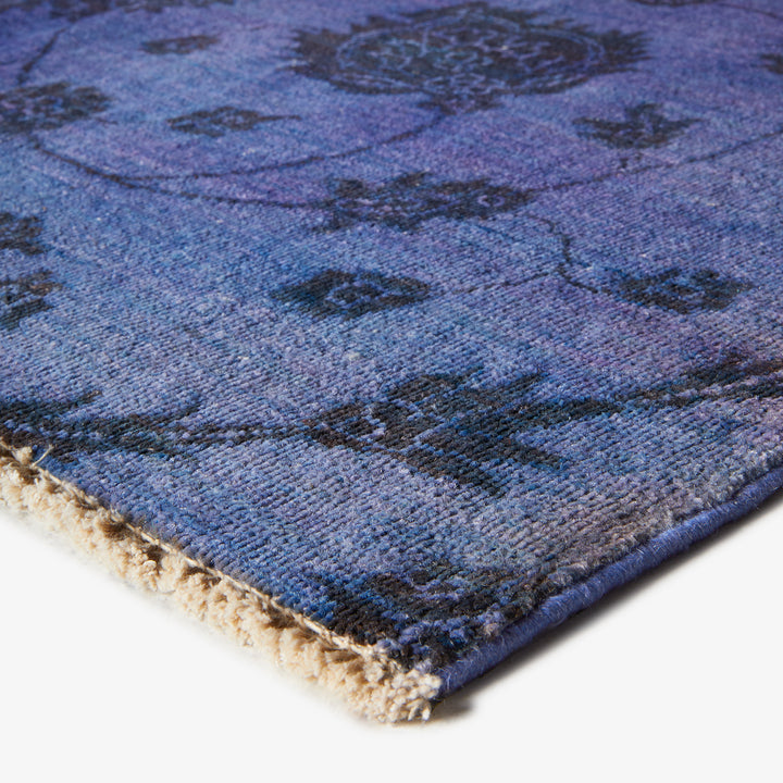 Close-up of blue distressed vintage rug with plush texture details.