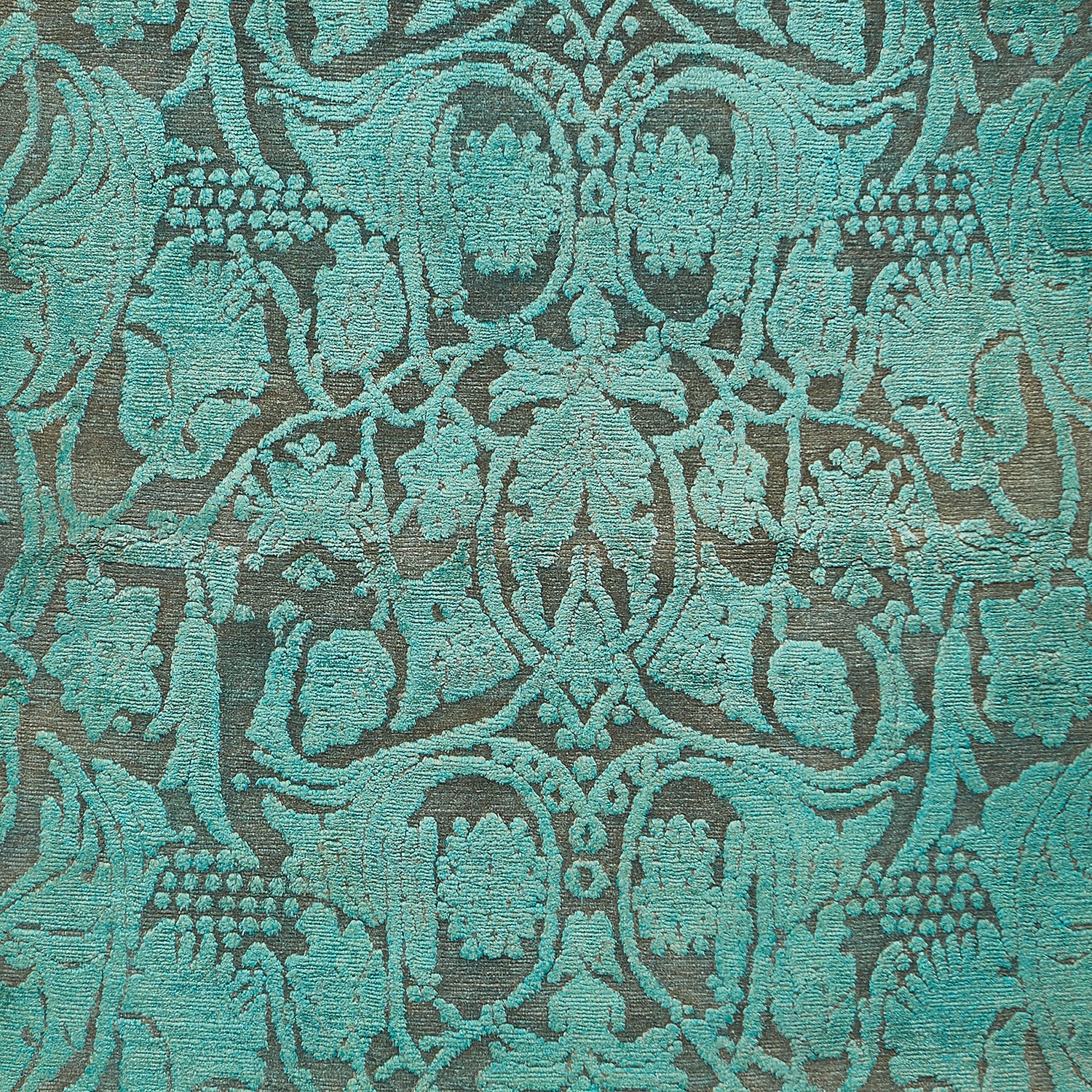 Intricate teal fabric with floral motifs in symmetrical pattern design.