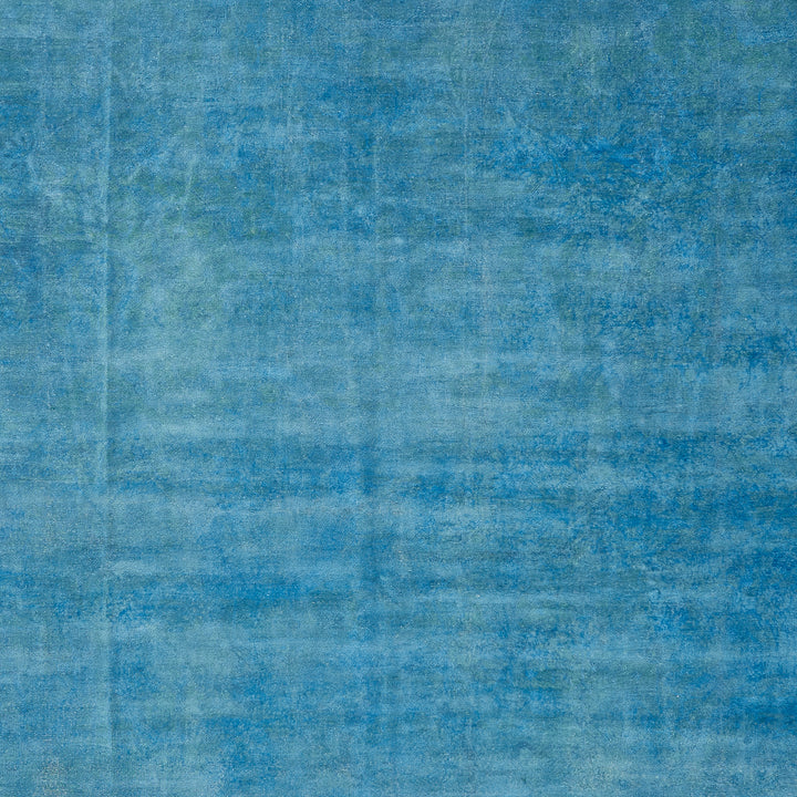 Textured surface with varying shades of blue, fabric-like appearance.