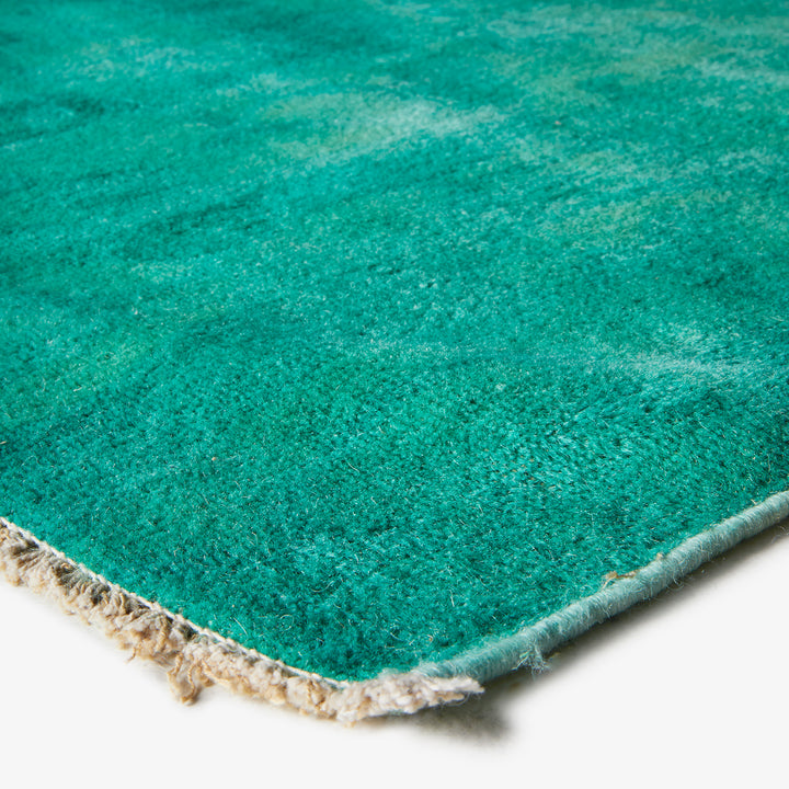 Close-up of turquoise rug, showing texture and vibrant color.