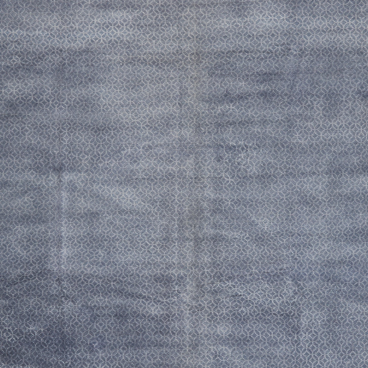 Close-up of blue denim fabric texture with diagonal twill pattern.