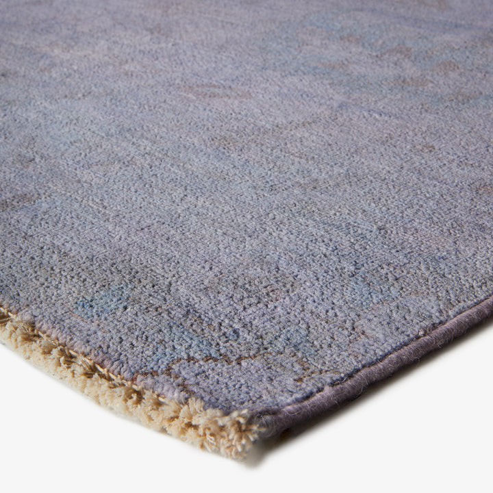 Close-up view of plush blue-gray carpet with beige binding edge.