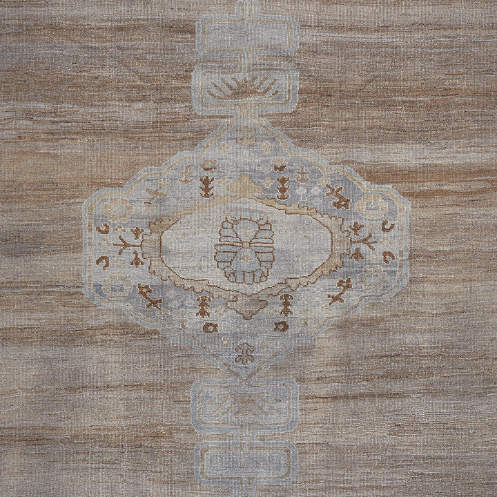 Vintage textile rug with intricate medallion design in brown tones.