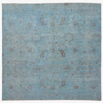 Traditional ornate rug with floral motifs on faded blue background.