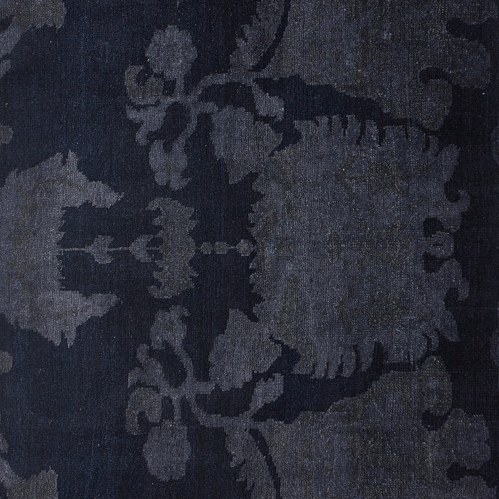 Close-up of elegant floral textile design on dark background fabric.