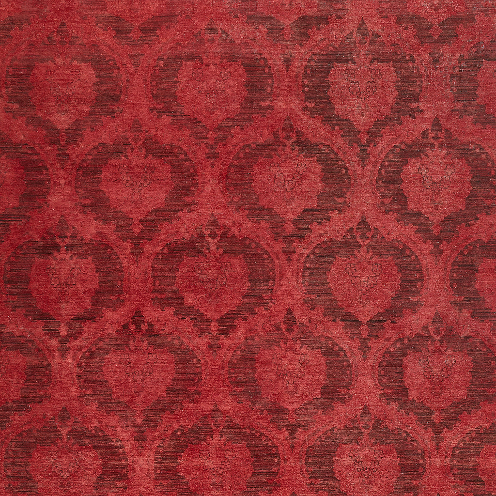 Close-up of ornate red fabric with vintage damask pattern design.