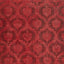 Close-up of ornate red fabric with vintage damask pattern design.