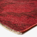 Close-up of red plush rug with subtle texture and pattern.