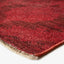 Close-up of red plush rug with subtle texture and pattern.