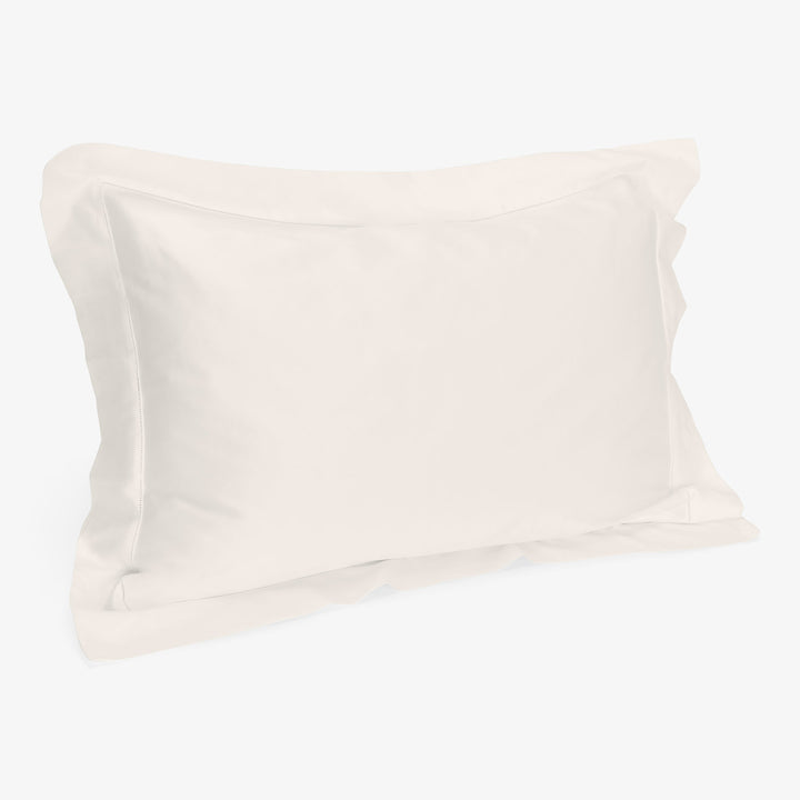 Soft white cotton pillow with fluffy filling against plain background.