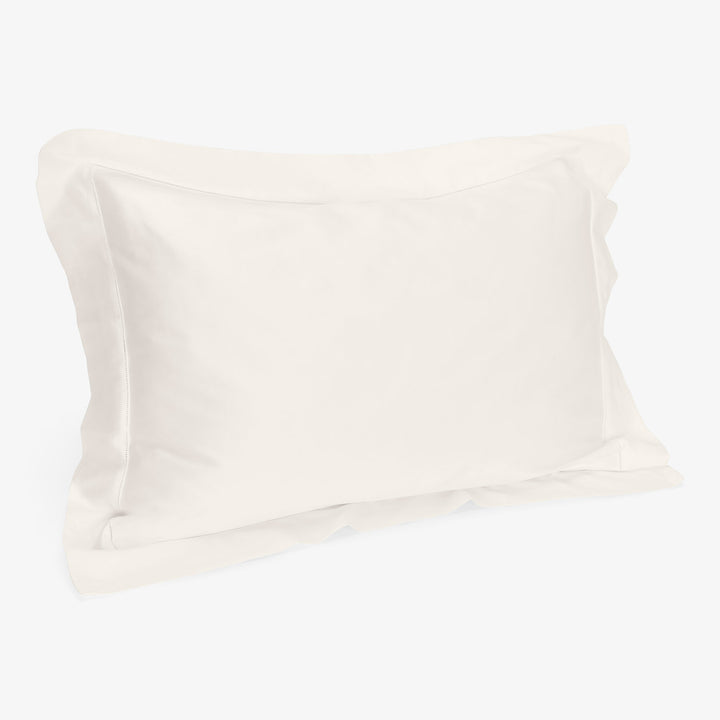 Minimalist white pillowcase with subtle decorative border on pillow.
