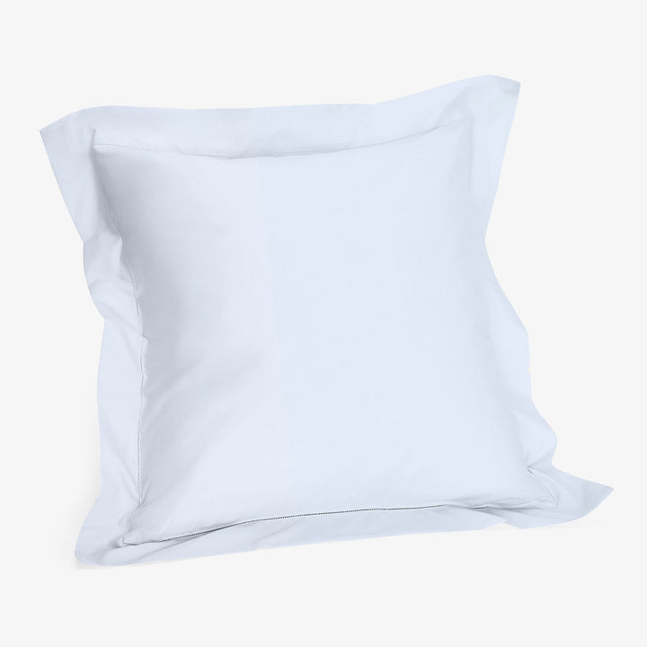 Minimalist white cotton pillow on plain white background.