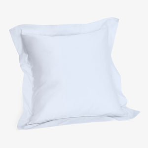 Minimalist white cotton pillow on plain white background.