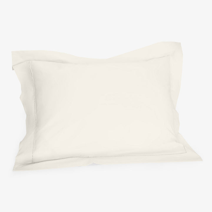 Minimalistic white pillowcase with flange on white background. Soft fabric.