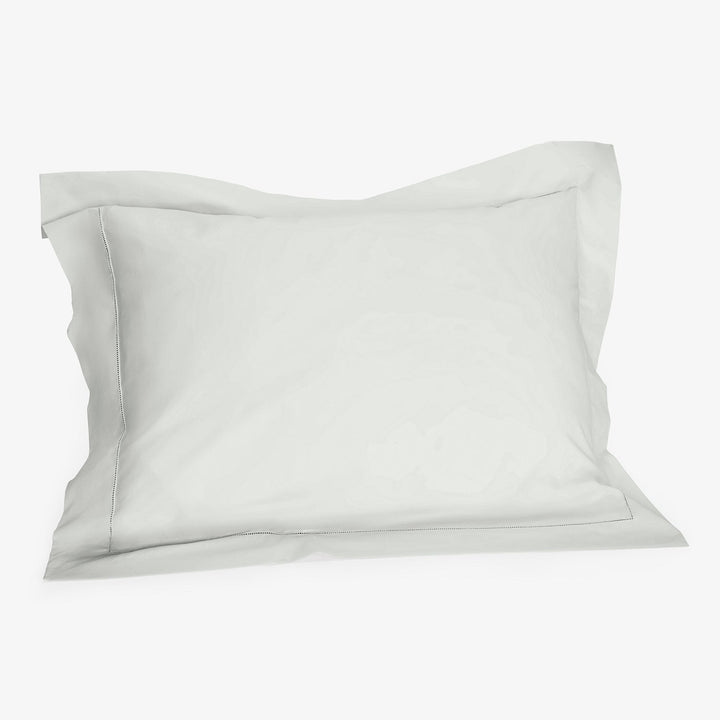 White cotton pillowcase with flange detail on clean background.