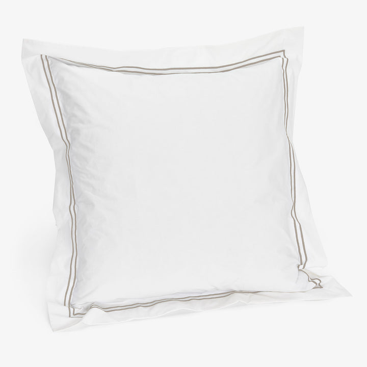 White pillow with grey piping border for elegant home decor.