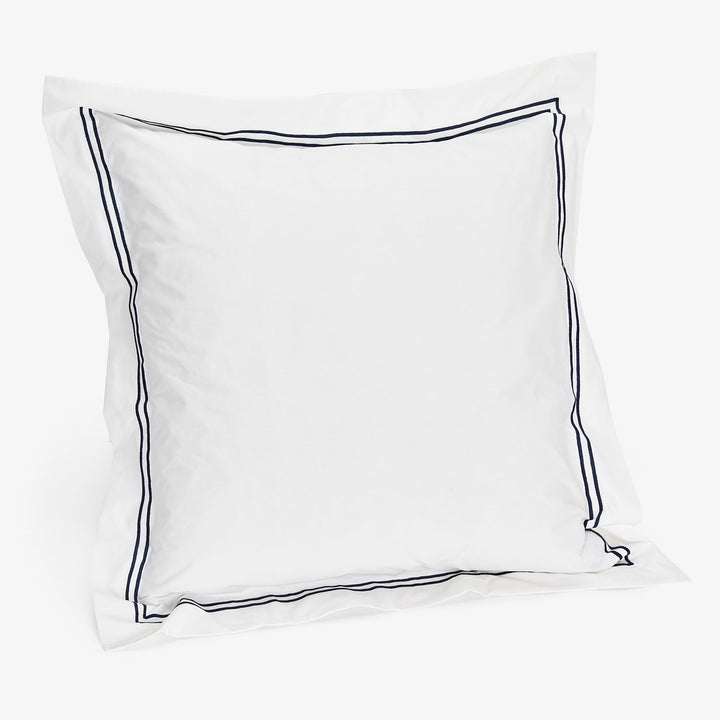 Minimalist white pillow sham with navy blue double-line border accent.