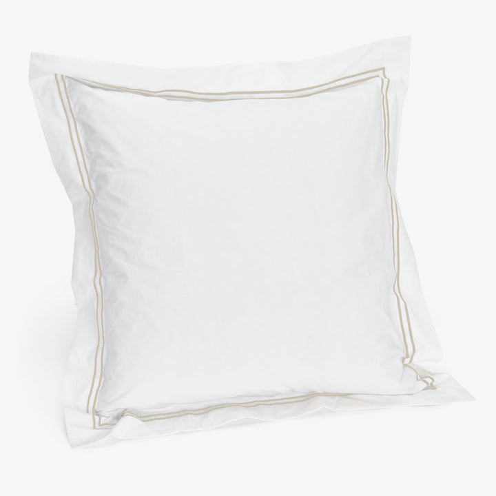 Plush white pillow with taupe piping, fluffy and comfortable design
