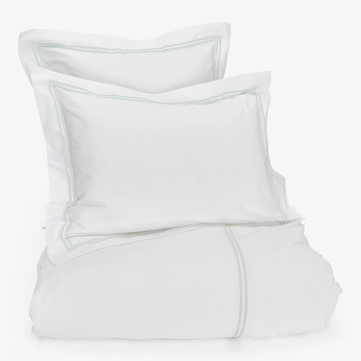 Fresh, clean white bedding with subtle green accents. Perfectly styled.
