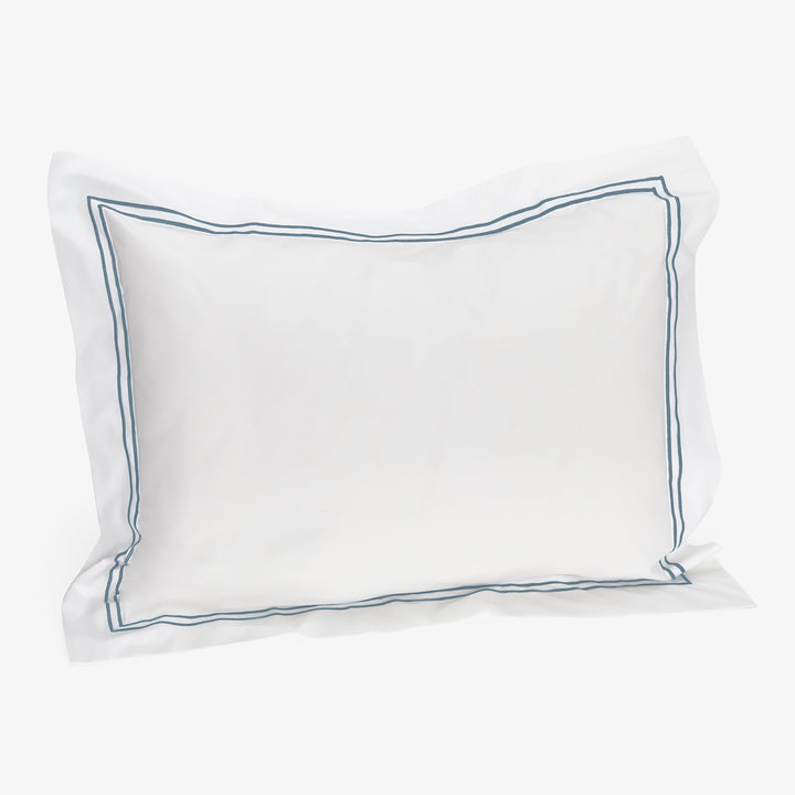 Soft white pillow with blue stripes, plush and cozy design.