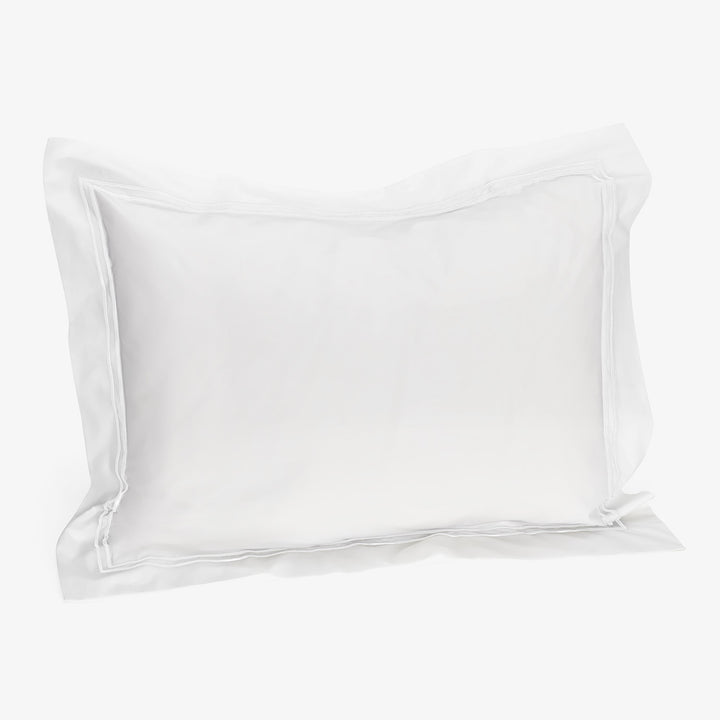 Empty white silky pillowcase with reinforced edges on white background.