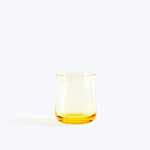 Modern clear glass pitcher with yellow tint, minimalistic setting.