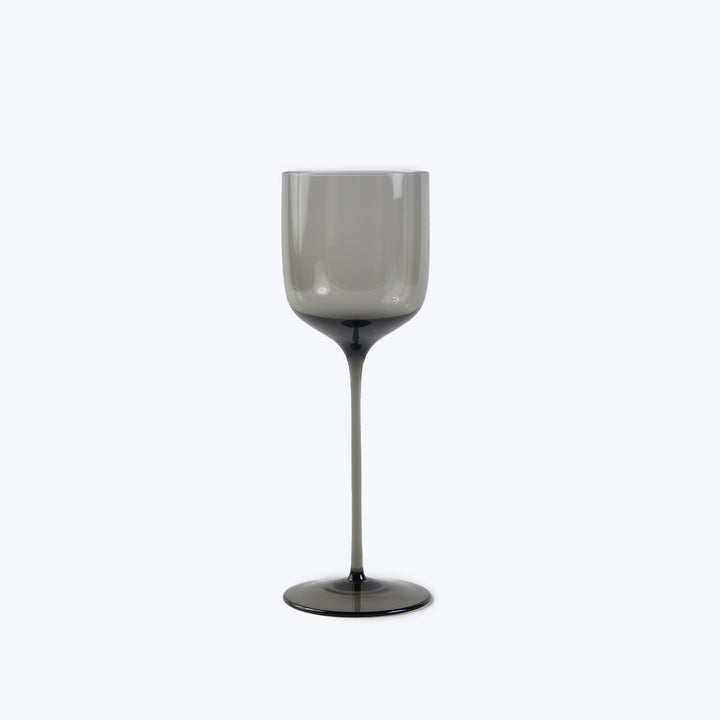 Modern smoky gray wine glass with sleek design on clean background.